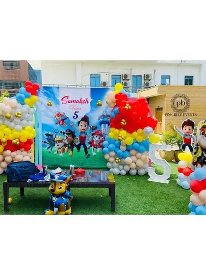 A full view of the Paw Patrol birthday setup on a lush green lawn. We can transform any outdoor space into a themed playground for your child's party.