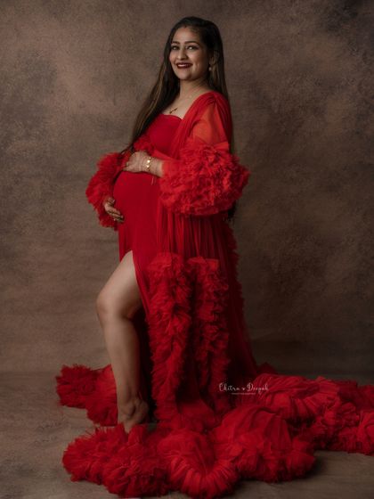 Confident and glowing. This side-slit red ruffled gown is perfect for showing off the baby bump while creating a glamorous and fashionable maternity portrait.