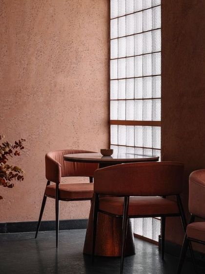 A quiet corner in Idylll, where the rough, earthy texture of the walls is the main feature. The minimalist furniture allows the architectural materials to speak for themselves.