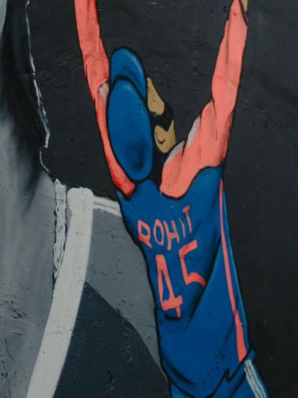 A close-up of the smaller, full-color figure celebrating in the Rohit Sharma mural. The contrast between the monochrome portrait and the colorful character makes the whole piece stand out.