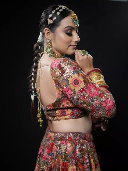 A detailed shot of the back of a bridal hairstyle. The long, thick braid is beautifully crafted and accessorized, offering a stunning view from every angle for this floral-themed bridal look.