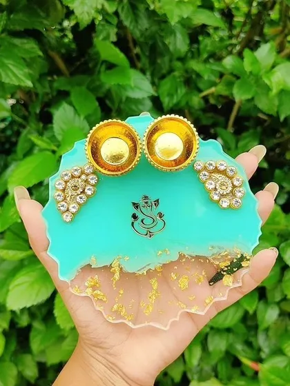 Celebrate festivals with a special touch. This is a custom resin platter I designed for Raksha Bandhan, featuring a vibrant turquoise base, a Ganesha motif, and holders for roli and chawal.