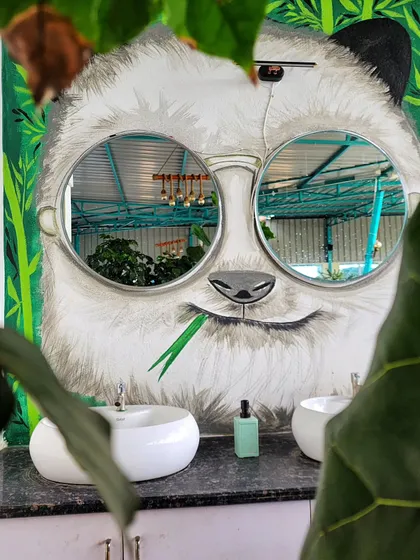 We love making art that's interactive and playful. For this washroom mural, we integrated two round mirrors as the panda's sunglasses, creating a fun and functional piece that reflects the viewer within the artwork.