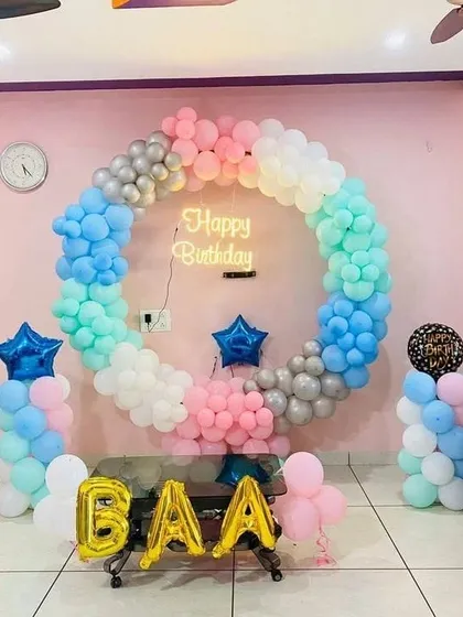 A pastel rainbow balloon ring with star-shaped foil balloons, perfect for a Father's Day celebration or birthday.