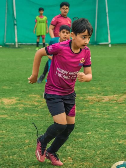 A player from Manav Rachna Football Club runs with the ball during a match.