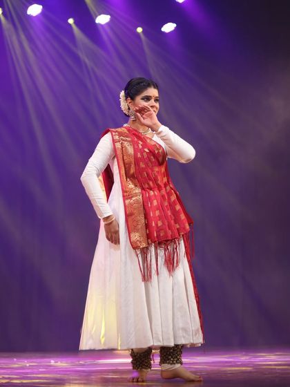 On stage, under the lights, I feel a divine connection. This photograph captures a moment of pure expression, where I am completely immersed in the rhythm and emotion of the performance.