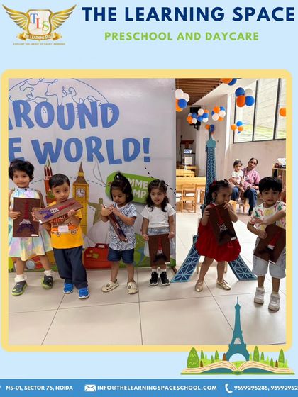 Our little travelers proudly display their European-themed creations. Holding their artwork, they stand before our "Around the World" backdrop, celebrating a day of creativity and cultural exploration.