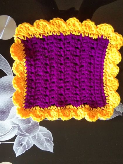 A square table mat in purple and yellow.