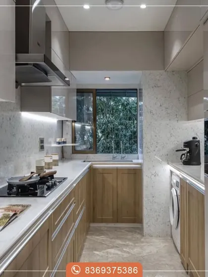 This galley kitchen is designed for maximum efficiency. The natural wood-finish cabinets provide warmth, while the white countertops and high-gloss upper cabinets reflect light, making the space feel larger and brighter.