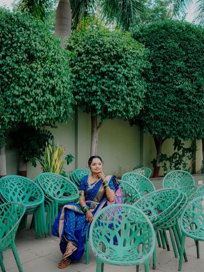 A creative and artistic portrait of the bride seated amongst a sea of green chairs, creating a unique and memorable composition.