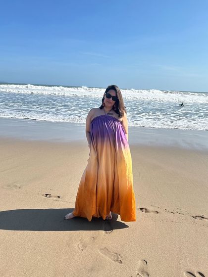 Wearing the same ombrè maxi dress on the beach in Bali. This shows how a versatile piece can be worn, and connects the fashion item to an aspirational travel moment.