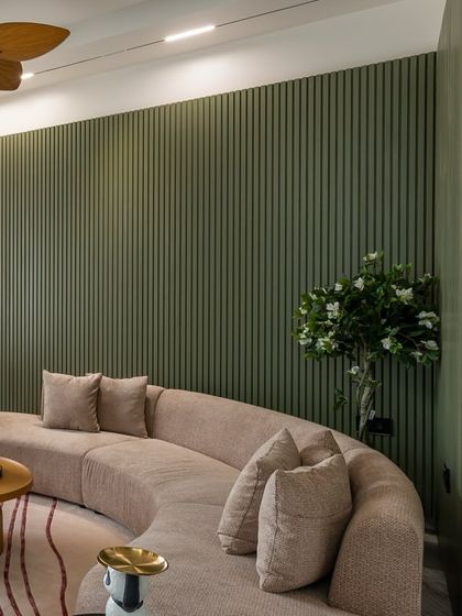 Another angle of the living room, showing the texture of the curved sofa and the depth created by the fluted wall paneling.