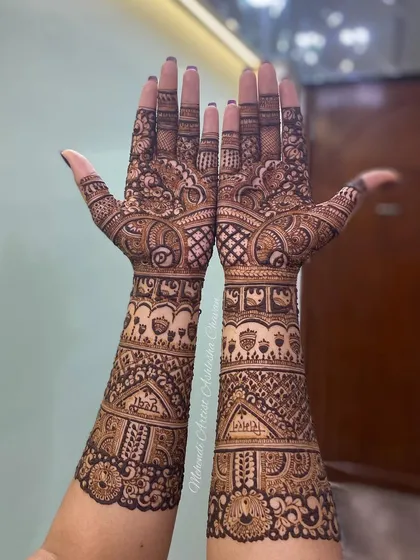 A full-arm mehendi design with a mix of patterns. The design is intricate and covers the hands and arms in a beautiful, flowing composition.