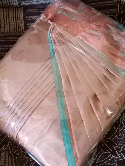 A pleated and box-folded saree, protected in its packaging.