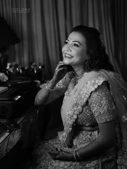 A classic black and white portrait of the bride getting ready, her face full of happiness.
