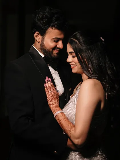 A tender moment between the couple, captured in a softly lit, romantic style that emphasizes their connection and elegant evening attire.