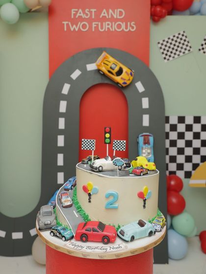 For a "Fast and Two Furious" second birthday, this cake features an edible racetrack and a collection of toy cars. It's a fun, interactive design that perfectly matches the high-energy theme of the party.