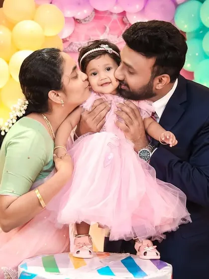 These are the moments we live for. We captured this beautiful, candid moment of parents sharing a kiss with their daughter on her first birthday, surrounded by a dreamy Cinderella-themed decor. Our goal is to freeze these precious family memories in time.