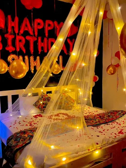 For a truly special birthday surprise, I design romantic bedroom decorations like this. The setup includes a delicate canopy, warm fairy lights, scattered rose petals, and a combination of foil and latex balloons to create a cozy and love-filled ambiance.
