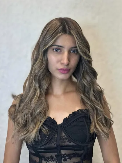 A beautiful portrait of the client with her new golden balayage. She looks absolutely radiant and confident.