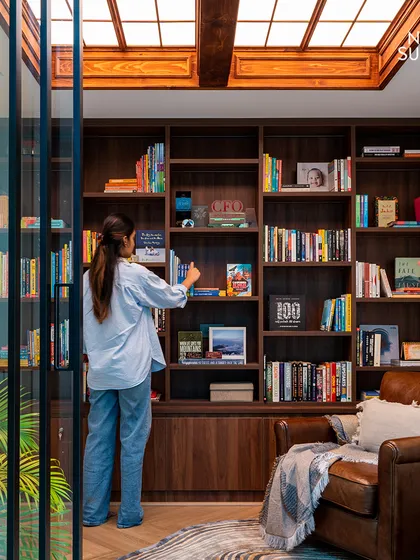 A library is more than a place for books; it's a cozy escape. We designed this personal library with floor-to-ceiling warm wood shelving and a modern skylight that fills the room with natural light. It’s a bright, welcoming retreat for getting lost in stories and ideas.