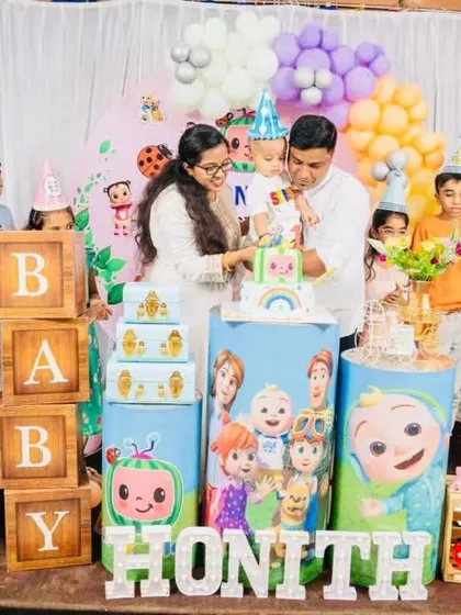 The happy family celebrating at a Cocomelon-themed first birthday party. It's wonderful to see the joy my setups bring to these special moments.