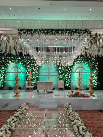 This is where fairytales come to life. I designed this ethereal mandap with a reflective glass aisle and a canopy of cascading white florals, creating a magical path for the couple to walk towards their forever.