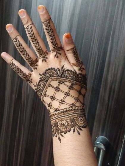 A stylish back-of-hand design featuring a geometric cuff and leafy vines on the fingers. This is a modern and trendy look, perfect for a party or festival.