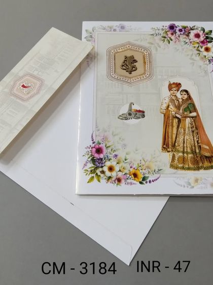 This card features a beautiful illustration of a bride and groom with a Ganesha emblem for blessings. The floral details and soft colors make it a charming choice.