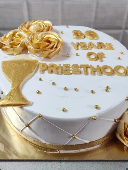 A cake celebrating 50 years of priesthood. This elegant white and gold design features a chalice and golden roses.