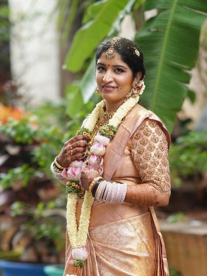 A beautiful bride with a lovely, rich mehendi stain, looking radiant in her golden saree.