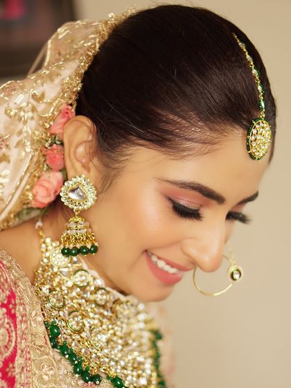 A beautiful candid moment with Aakriti, looking absolutely stunning on her wedding day. Her glowing skin and the subtle elegance of her makeup capture the pure joy of the occasion.