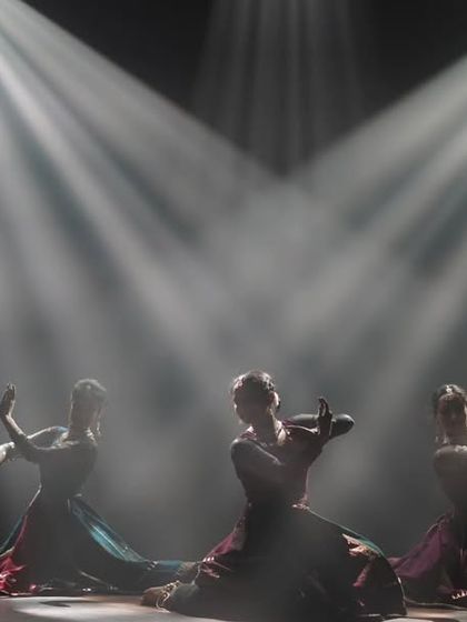 A dramatic silhouette of our dancers on stage. The use of smoke and spotlights creates a mystical atmosphere, highlighting the powerful forms and postures of Kathak.