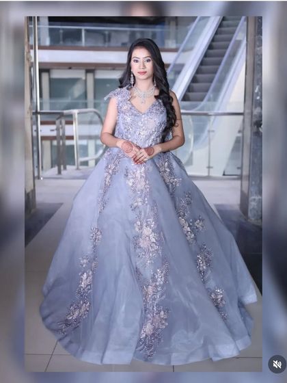 A fairytale gown in a lovely lavender-grey shade. The tulle skirt is adorned with delicate floral appliqué, making it a dreamy choice for a reception or pre-wedding shoot.