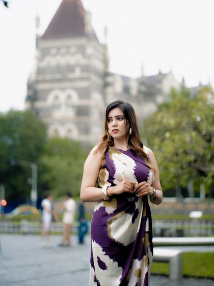 A candid, thoughtful portrait. The blurred background of the historic building adds a sense of place without distracting from the subject.