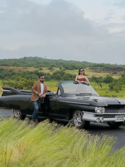 A powerful wide shot of the couple with their classic Cadillac against the backdrop of the Goan hills. This is a true statement photo.