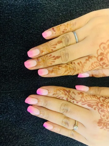 A soft and beautiful pink ombre effect. This design blends a neutral base into a bright pink tip, creating a gentle gradient that looks both modern and elegant, perfectly complementing the client's henna.
