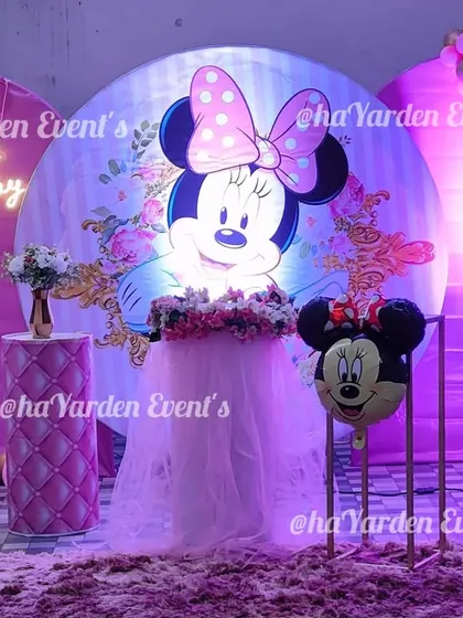 A classic and beloved Minnie Mouse theme. This setup features a large illuminated Minnie Mouse backdrop, pink balloon arches, and a themed pedestal with a tulle skirt.