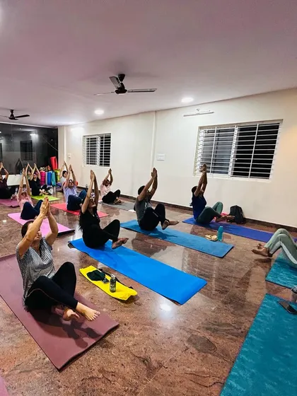 A group of students working on their core strength with a variation of Boat Pose. A strong core is essential for stability in many other yoga postures.