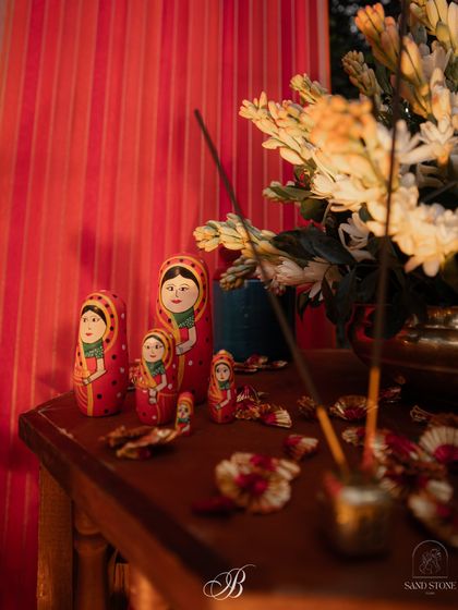 A close-up of the antique table at the reception stage, featuring Russian nesting dolls alongside traditional Indian elements. This reflects the couple's story and creates a unique, personalized tablescape.