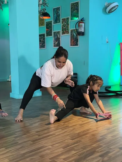 Here, I'm pointing out the correct alignment for a side lunge stretch. It's important that the knee stays over the ankle and the hips sink low to get the full benefit of the stretch without risking injury.