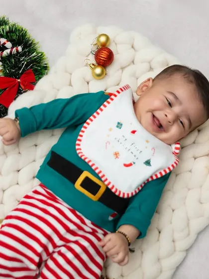 Dressed as Santa's little helper, this baby's sweet smile is the perfect Christmas gift. These simple, themed setups are great for capturing your baby's first holiday season.