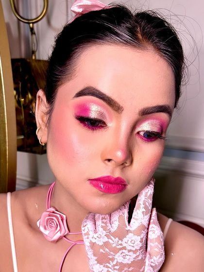 A close up of the Barbie inspired makeup look. The dual-toned pink and shimmer eyeshadow, glossy pink lips, and rosy cheeks create a playful and glamorous vibe.