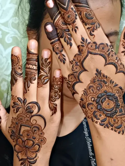 A beautiful party henna design with a bold rose motif on the back of the hand.