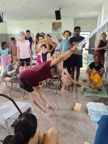 Demonstrating a pose with wall ropes to a class.