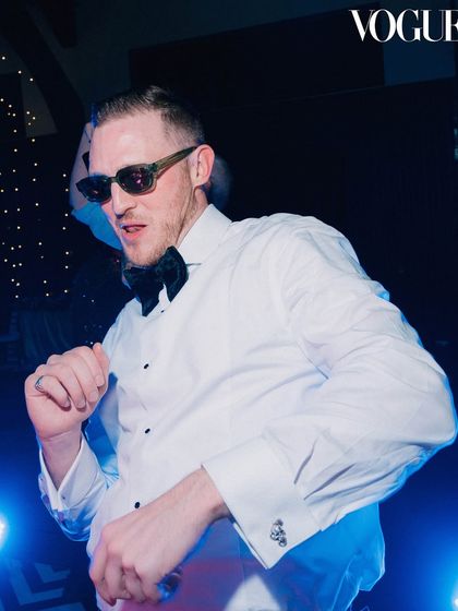 The groom owning the dance floor. This cool, candid shot with dramatic lighting captures the fun and high-energy vibe of the wedding after-party.