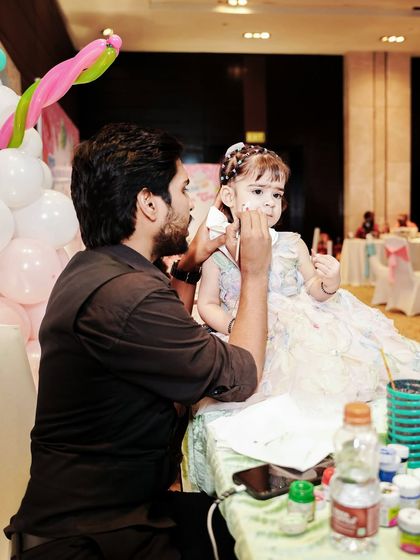 A tattoo and face painting artist at work during a Candyland themed party.
