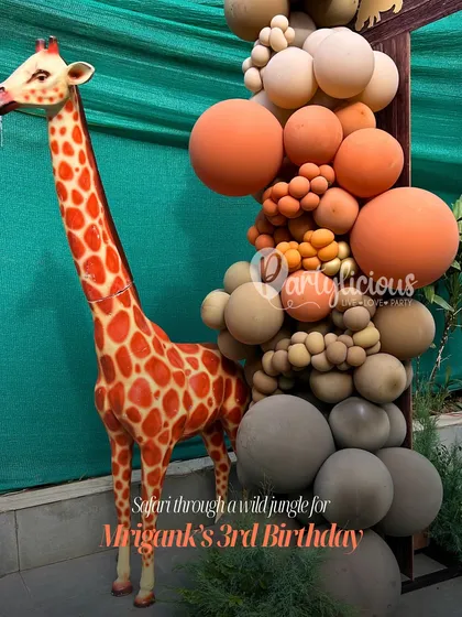 A safari through a wild jungle for Mrigank's 3rd Birthday. This shot captures our tall giraffe prop next to a beautiful organic balloon garland in earthy orange, brown, and tan tones.