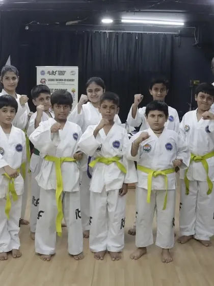 Another proud group of newly promoted yellow belts with their instructors.