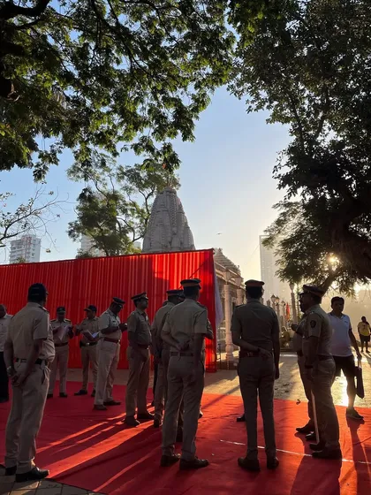 A behind-the-scenes look at the police presence during the Shiv Jayanti event, with the temple visible in the background. It shows the layers of activity at a large public gathering.